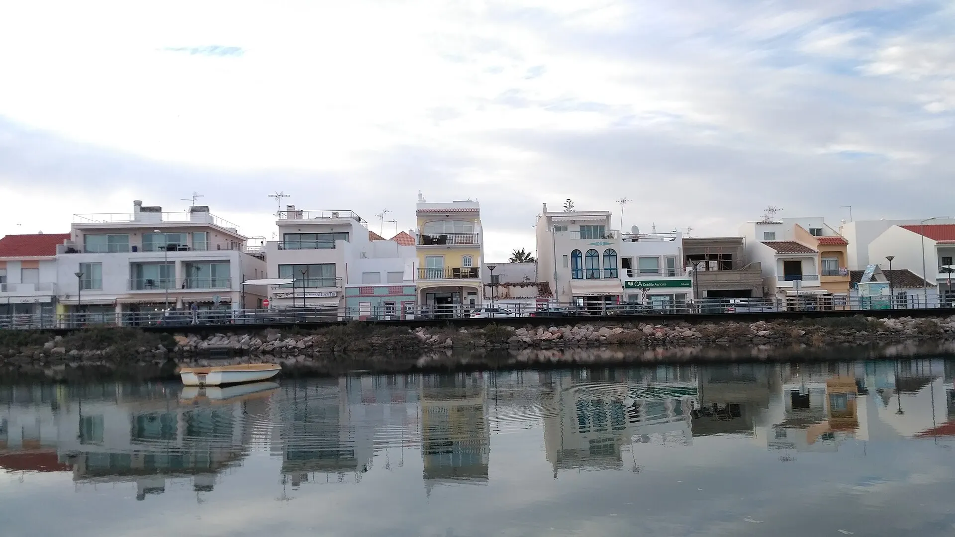 Cabanas de Tavira vista da Ria Formosa, com um barco na água
