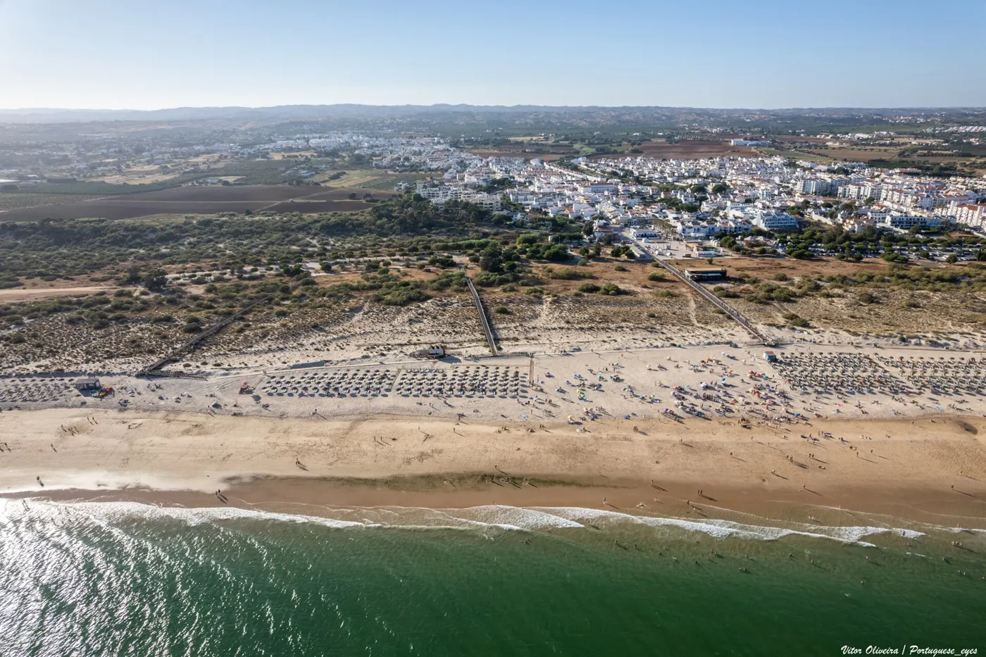 Aerial view of Manta Rota beach and the village, with bathers, in July 2025